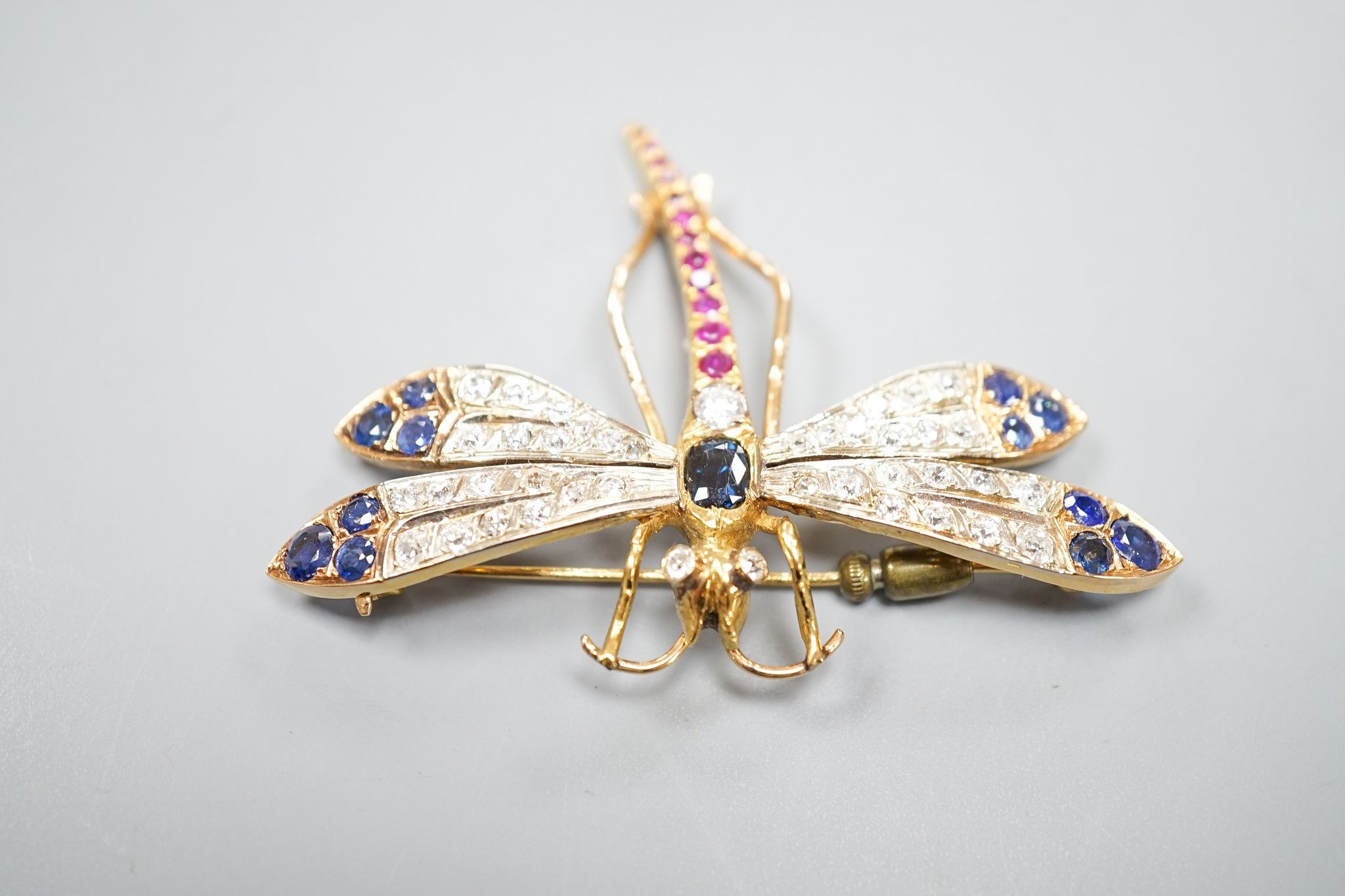 A Victorian style 14k, ruby, sapphire and diamond set dragonfly brooch, 47mm, gross weight 18.5 grams.